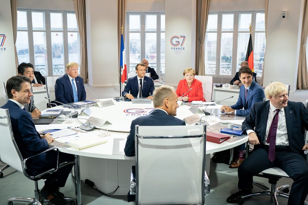 Picture of the G7 leaders meeting in France 2019 seated around a round table for discussions.  The G7 includes leaders of France, Germany, UK, Italy, EU, Japan, Canada and US. 